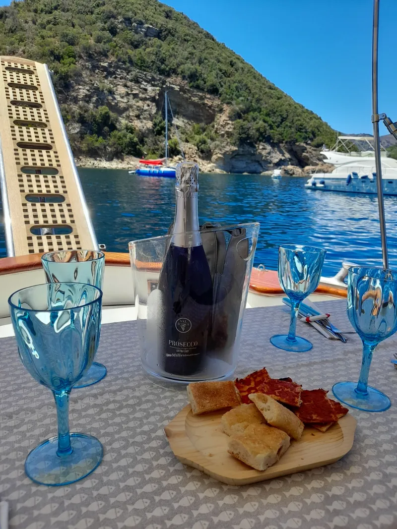 Aperitivo a bordo con bollicine e stuzzichini, in rada
