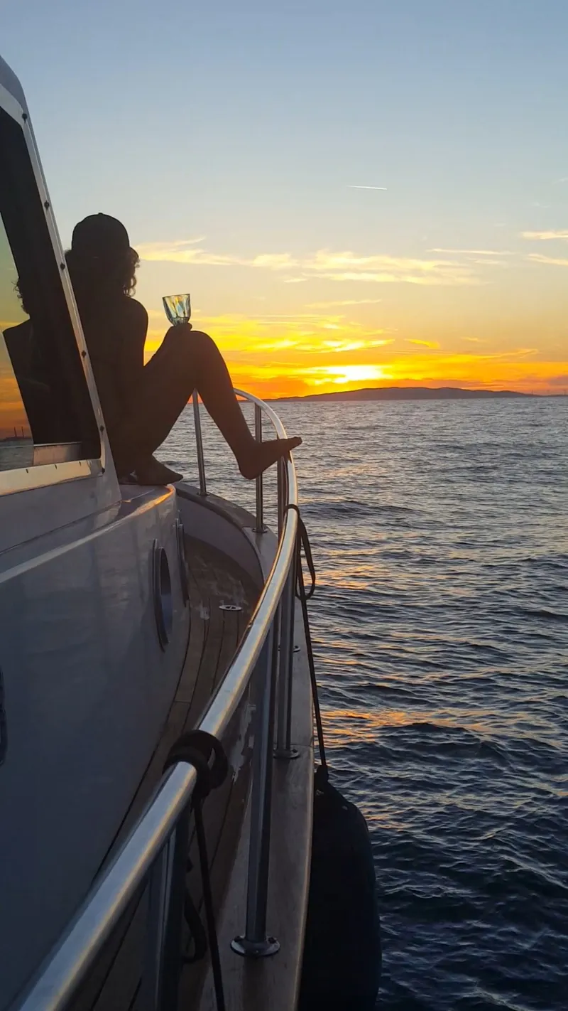 Un ospite guarda il tramonto dal bordo della barca